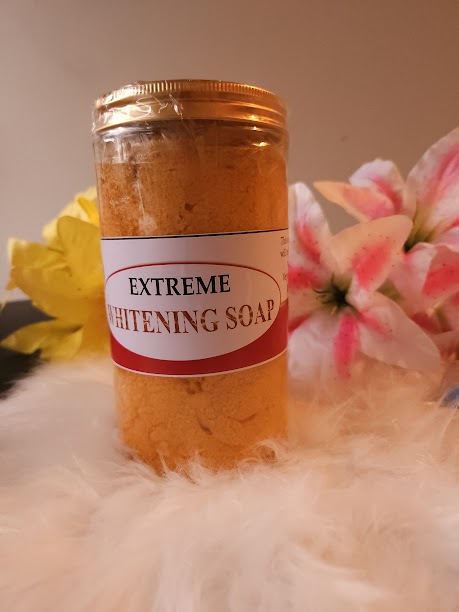 Jar of 'Extreme Whitening Soap' with a label, placed on a textured surface with flowers in the background.